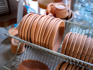 Fototapeta na wymiar Row of terracotta dishes on old stainless steel shelf
