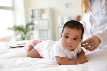 Pediatrician examining African-American baby in clinic