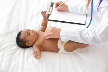 Obraz na płótnie Canvas Pediatrician examining African-American baby in clinic