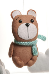 Colorful and eco-friendly children's mobile from felt. A felt toy in the form of a lovely bear, part of a children's mobile. On a white background.