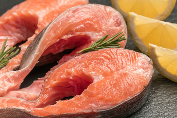 Raw salmon, trout steak on a dark slate background. Wild atlantic fish. Healthy food.
