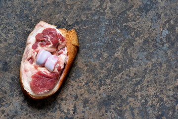 Pork steak with bacon on the kitchen stone table. View from above.
