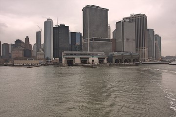 Manhattan skyline with river in foreground on cloudy, rainy day with gray sky