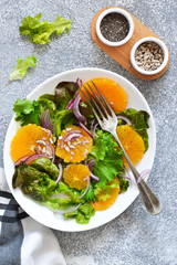Detox nutrition. Salad with orange, onion and seeds on the kitchen table. View from above.
