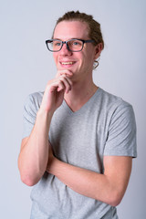 Portrait of happy young handsome man with eyeglasses thinking