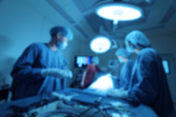 Blur of group of veterinarian surgery in operation room for laparoscopic take with art lighting and blue filter