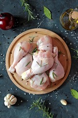Raw uncooked chicken legs with ingredients for cooking, drumsticks on wooden board. Top view with copy space. © Ale02