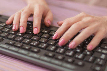 Woman typing on the keyboard. Housewife works at the computer.