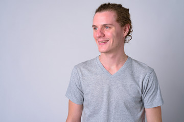 Portrait of happy young handsome man smiling and thinking