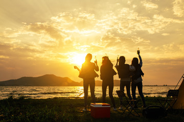 Fototapeta na wymiar Silhouette Group of women party and dancing with drink bottles enjoy travel camping,trekking in vacation time at sunset.