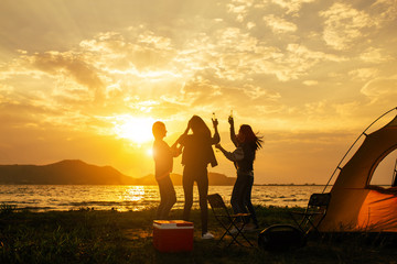 Obraz na płótnie Canvas Silhouette Group of women party and dancing with drink bottles enjoy travel camping,trekking in vacation time at sunset.