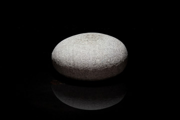 Fototapeta na wymiar Single stone - dark background - zen concept