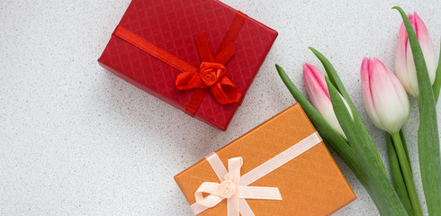 three delicate pink tulips with gift box and copy space