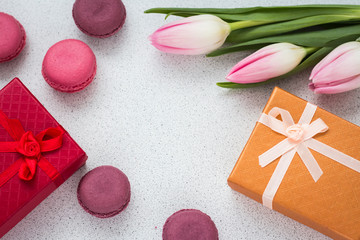 layout of almond cookies with a bouquet of pink tulips and a gift in a box with a copy of space