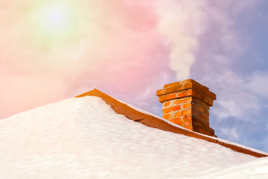 Smoke Raising From A Chimney In Snny Winter