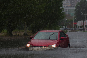 car rides in heavy rain on a flooded road