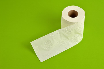 White roll toilet paper on green background