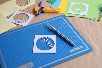 Making tunnelbook. 3D greeting card Spring . Artwork equipment and tools for paper cut - cutting knife, sharp box cutter, blue cutting plate, origami paper. Modern 3d origami paper art style.