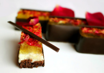 Lemon and chocolate dessert with rose petals on white background