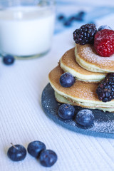 Delicious homemade pancakes with berries and milk