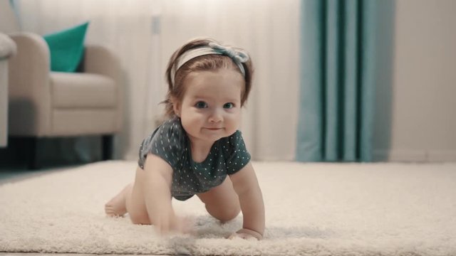 Baby girl crawling on all fours on floor at home