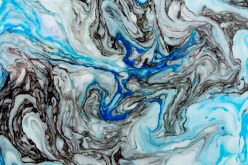 Abstract beautiful marbling with white and blue colors.The Eastern style of Ebru painting on water with acrylic paints swirls marbling.A stylish mix of natural luxury 