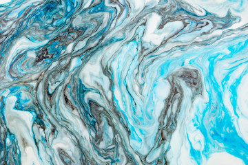 Abstract beautiful marbling with white and blue colors.The Eastern style of Ebru painting on water with acrylic paints swirls marbling.A stylish mix of natural luxury 