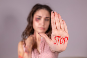 Domestic violence, protesting and people concept - brunette woman expressing denial with STOP on...