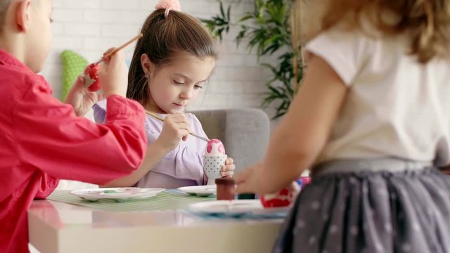 Group of children painting easter eggs 