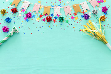 Party colorful confetti over light pastel blue wooden background . Top view, flat lay