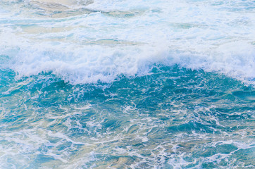 Top view sea texture. Foaming blue water surface. Sea water with foam. Blurred in motion.