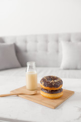 Chocolate donut. Morning breakfast with milk on table in living room at home.
