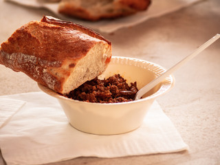 A person eating on the street in a paper plate with a plastic fork at a party