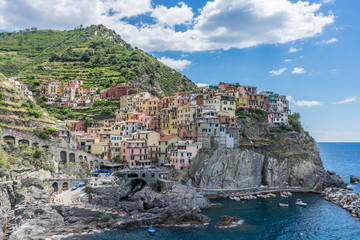 Fototapeta na wymiar Italy, Cinque Terre, Manarola, Cinque Terre, a group of people standing next to a body of water with Cinque Terre in the background