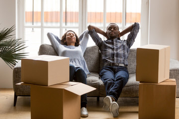 Black young couple relax on couch tired on moving day