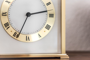 golden and white clock in front of a white wall