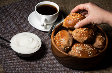 Female hand takes a pie from a wooden plate.