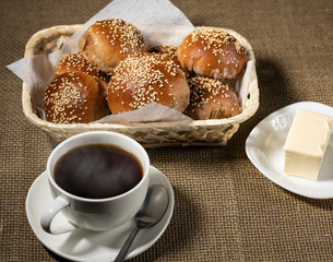 Traditional breakfast with hot drink and fresh sesame buns.