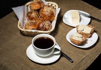 Traditional breakfast with hot drink and fresh sesame buns.