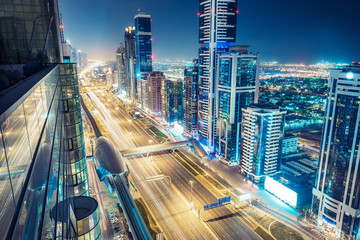 Aerial view over downtown Dubai, UAE.  Nighttime skyline of a big modern city with skyscrapers and highways.