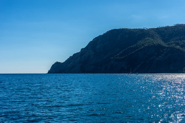 Italy, Cinque Terre, Monterosso, a large body of water with a mountain in the background
