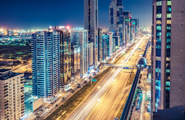 Fototapeta na wymiar Aerial view on downtown Dubai, UAE with highways and skyscrapers. Scenic nighttime skyline.