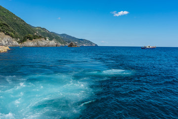 Fototapeta na wymiar Italy, Cinque Terre, Monterosso, a body of water with a mountain in the ocean