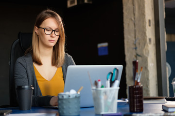 A girl works at a computer in a modern office