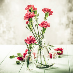 Obraz na płótnie Canvas Toned photo with bouquet of pink carnation in glass vase. Mothers day, birthday greeting card.