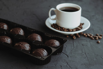 Chocolate cakes and cup of coffee on dark background