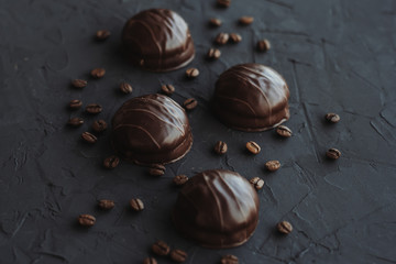 Chocolate cakes and coffee beans on a black background