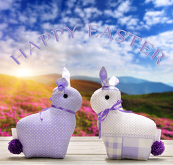 Two Easter yellow bunnies with happy easter text. Easter holiday concept.