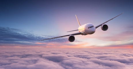 Fototapeta premium Odrzutowiec samolotu komercyjnego latające nad chmury dramatyczne w pięknym świetle słońca. Koncepcja podróży.