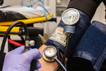 closeup of professional checking blood pressure to patient in an ambulance